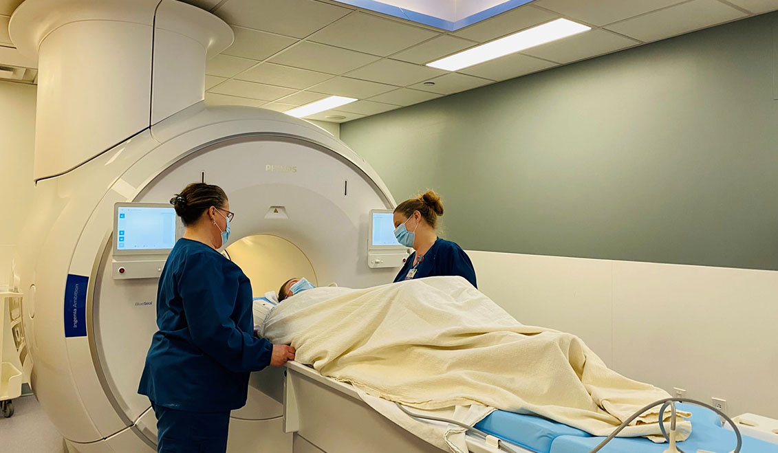 two techs assisting a patient in an MRI